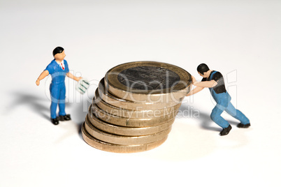 Miniatur Arbeiter schiebt Münzen