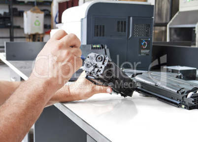 hands repairing toner cartridge