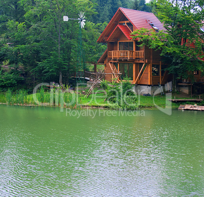 Lake with the wooden house ashore in the summer