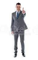 Confident businessman gesturing thumbs up