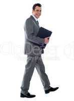 Businessman holding documents and walking