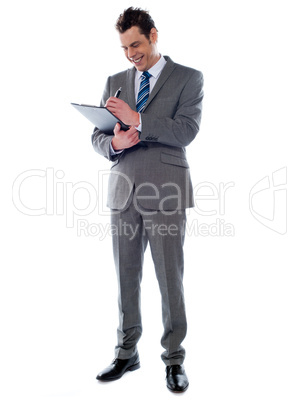 Successful businessman writing notes on clipboard