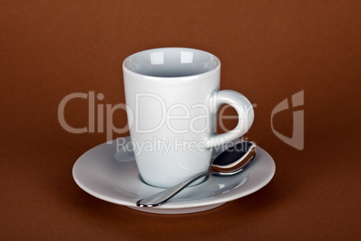 white coffe cup with coffe beans and a silver spoon