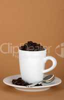 white coffe cup with coffe beans and a silver spoon