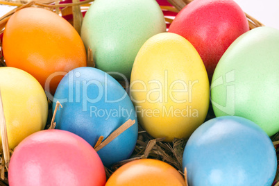 eastern eggs in different colours in a basket with a rabbit