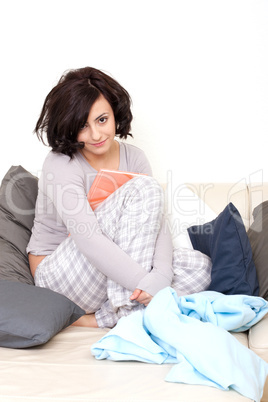 beautiful woman is sitting on the sofa an reading a book