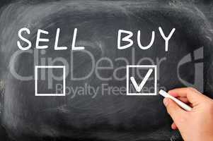 Buy or sell check boxes written on a blackboard