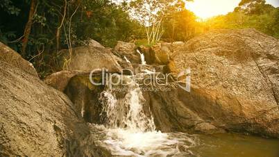 Waterfall in summer mountain at sunset