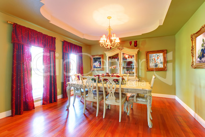 Large green dining room with cherry hardwood.