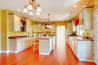 Gold kitchen with white antique cabinets.