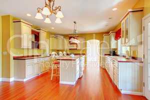 Gold kitchen with white antique cabinets.