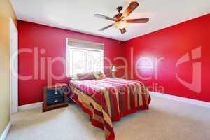 Red bedroom with bed and nighstand.