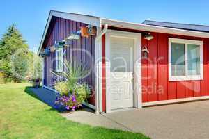Shed in purple and red with bird houses.