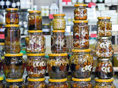 glass jars with nuts and honey on display in a store