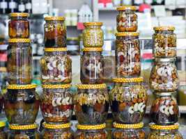 glass jars with nuts and honey on display in a store
