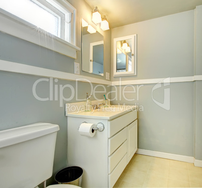 Grey bathroom with white simple cabinet.