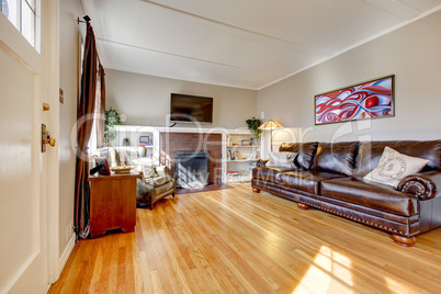 Living room with leather sofa, fireplace and TV.