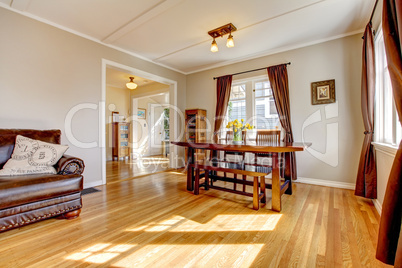 Dining room with brown curtain and hardwood floor.