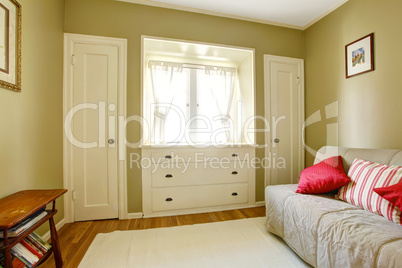 Green bedroom with white doors and dresser.