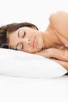 A woman sleeping on the bed with her head resting on the pillow,