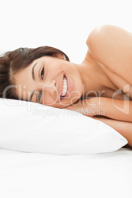 A woman lying on the bed, her head on the pillow, her eyes are o