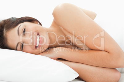 A woman is lying on the bed, her head is resting on the pillow w