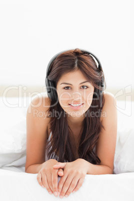 Woman looking forward with a smile, her hands together while lis