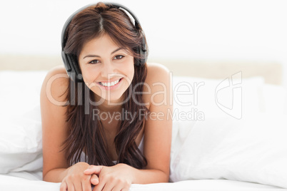 Woman tilting her head slightly while listening to music and smi