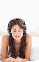 Close up of woman listening to her headphones with her eyes clos