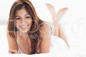 Woman lying down, smiling with her legs crossed and raised up