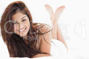 Woman lying down with her legs crossed and raised, smiling with
