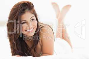 Woman smiling while looking to the side with her legs raised and