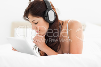 Woman with a look of concentration on her face as she uses a tab