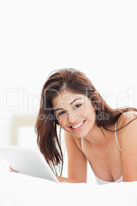 Woman smiling and looking forward and holding a tablet