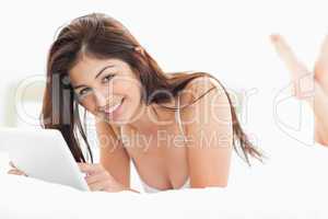 Woman looking forward smiling with crossed legs while browsing t