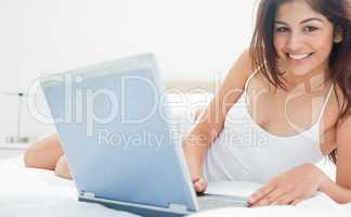 Woman looking forward as she holds her laptop and relaxing on he