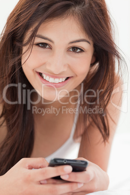 Close up, Smiling woman with her smartphone in hand