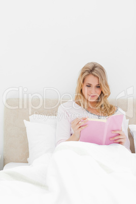 Closer shot, Woman reading her book while sitting in bed