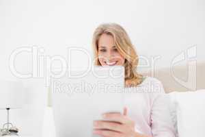 Low angle shot, woman using tablet pc and smiling