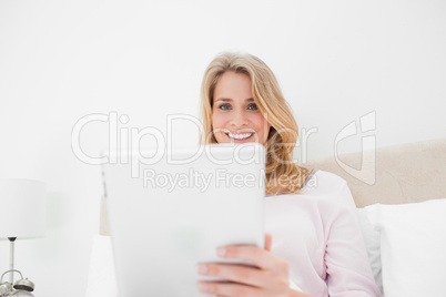 Low angle shot, woman using tablet pc in while smiling and looki