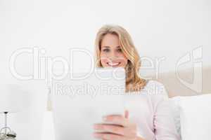 Low angle shot, woman using tablet pc in while smiling and looki