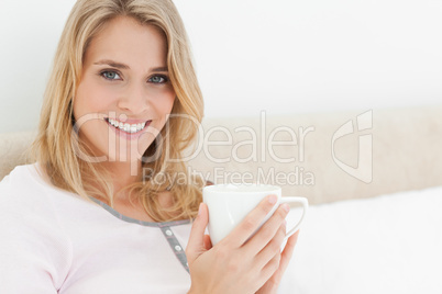 Close up, Woman holding a cup in her hands, while looking ahead