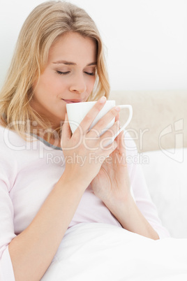 Close up, Woman holding a cup up to her face, her eyes closed