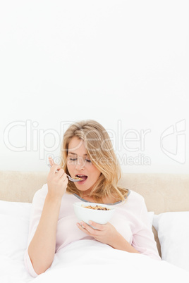 Vertical shot, Woman about to eat a spoon of cereal with her mou