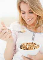 Close up, woman with a bowl and raised spoon of cereal in her ha
