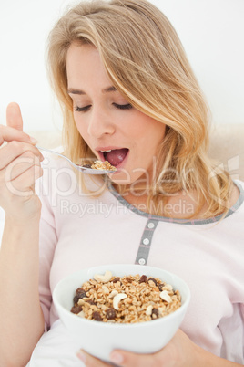 Close up, Woman about to eat a spoon of cereal, with a bowl in h