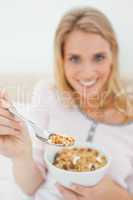 Focus shot, woman offering a spoon of cereal, focused on the spo