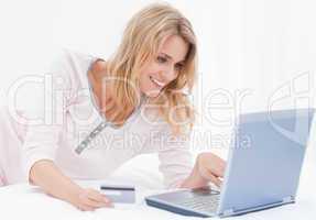 Woman smiling using her credit card and laptop to order online