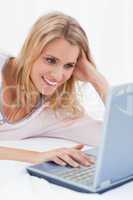 Close up, Woman using her laptop, looking at the screen and smil