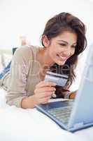 Close up , woman with credit card looking at laptop and smiling